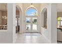 Bright foyer featuring arched entryways, tile flooring, and a glimpse of the home's open and airy layout at 1923 Lazy Oaks Loop, St Cloud, FL 34771