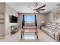 Cozy living room with plush seating, modern ceiling fan, and large window at 194 Henry Steven Dr, Haines City, FL 33844