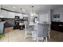 Well-lit kitchen featuring a kitchen island, modern appliances, and an adjacent dining area at 2015 Barstow Ln, Dundee, FL 33838