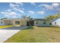 Charming home with a covered carport and green lawn under a sunny sky at 224 Pennsylvania Ave, St Cloud, FL 34769