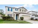 Attractive home with a well-manicured lawn, inviting blue shutters, and a two-car garage at 283 Willow View Dr, Davenport, FL 33896
