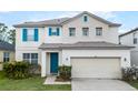 Charming home featuring a blue front door and shutters, complemented by a two-car garage at 283 Willow View Dr, Davenport, FL 33896