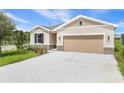 Attractive single-Gathering home featuring an attached 2-car garage and a manicured lawn at 306 Alexandrite St, Deland, FL 32720