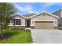Charming one-story home featuring stone accents, neutral stucco, and a two-car garage at 306 Alexandrite St, Deland, FL 32720