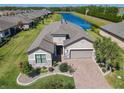 Beautiful house with lush landscaping, a brick driveway, and a water view at 307 Bella Cortina Dr, Kissimmee, FL 34759