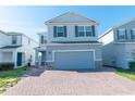 Beautiful two-story home with a brick driveway and attached two-car garage at 3173 Armstrong Spring Dr, Kissimmee, FL 34744