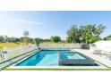 Resort-style pool and spa surrounded by white fencing and lush landscaping at 3173 Armstrong Spring Dr, Kissimmee, FL 34744