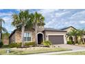 Well-maintained front yard featuring palm trees, decorative stone, and manicured lawn leading to a charming home at 333 Almansa St, Davenport, FL 33837