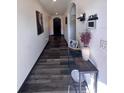 Inviting hallway with dark wood-look floors, white walls and trim, and arched doorways with decorative accents at 377 Holly Berry Dr, Davenport, FL 33897