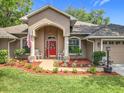 Inviting front porch with rocking chairs, vibrant flowers, and a patriotic American flag display at 4907 Raylene Way, St Cloud, FL 34771