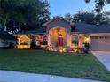 Charming home with landscaped front yard, beautiful illumination, and welcoming red door at 4907 Raylene Way, St Cloud, FL 34771