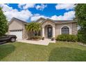 Inviting home featuring stone accents, a well-kept lawn, and a welcoming front entrance at 4910 Culdesac Ct St, St Cloud, FL 34772