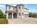 Beautiful two-story home with a three-car garage, stone facade, and a well-manicured lawn at 7665 Fairfax Dr, Kissimmee, FL 34747