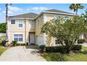 Charming two-story home with a well-manicured lawn and beautiful landscaping at 814 Bloomingdale Dr, Davenport, FL 33897