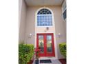 Close up on a red double front door and large arched window at 907 Gloucester Ct, Kissimmee, FL 34758