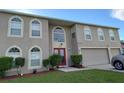 Two story home with large windows and a red double door at 907 Gloucester Ct, Kissimmee, FL 34758