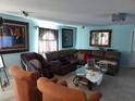 Living room featuring blue walls, tile floors and a comfortable brown sectional sofa at 907 Gloucester Ct, Kissimmee, FL 34758