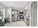 Functional kitchen featuring stainless steel appliances, tile flooring, and ample cabinet space at 1225 Coral Coast Dr, Orlando, FL 32824