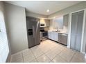 Bright kitchen features stainless steel appliances, white subway tile backsplash, and light gray cabinets at 1225 Coral Coast Dr, Orlando, FL 32824