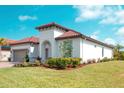 Beautiful home featuring a well manicured lawn and landscaping with lush shrubs and colorful flowers at 3704 Via Monte Napoleone Dr, Poinciana, FL 34759