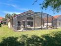 Backyard screened-in pool featuring an outdoor seating area and lush landscaping at 1102 Solana Cir, Davenport, FL 33897
