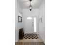 Bright entryway with light wood floors, a patterned rug, and decorative boxes beside the front door at 1821 N Hampton Dr, Davenport, FL 33897