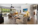 Open-concept living room features hardwood floors, comfortable seating, and natural light from large windows at 1821 N Hampton Dr, Davenport, FL 33897