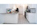 Bright kitchen featuring white cabinets, granite countertops, and modern black appliances at 201 La Paz Dr, Kissimmee, FL 34743