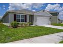 Charming home featuring a two-car garage, manicured lawn, and well-maintained landscaping at 2705 Grandbury Grove Rd, Lakeland, FL 33811
