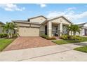 Inviting home featuring a two-car garage, manicured landscaping, and a covered front porch at 2748 Greenlands St, St Cloud, FL 34772