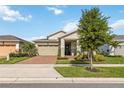 Well-maintained single-Gathering home with manicured lawn, brick driveway, and a two-car garage at 2748 Greenlands St, St Cloud, FL 34772