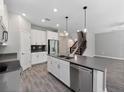 Well-lit kitchen featuring stainless appliances, white cabinets, a center island with a double sink, and tile floors at 3038 Camden Way, Davenport, FL 33837