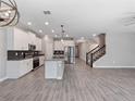 Open-concept kitchen featuring white cabinets, stainless steel appliances, a center island, and tile flooring at 3038 Camden Way, Davenport, FL 33837