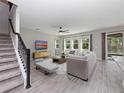Bright living room with neutral walls, ceiling fan, tile floors, and large windows letting in natural light at 3038 Camden Way, Davenport, FL 33837