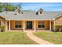 Inviting home entrance with classic columns, large windows, and a brick walkway at 3075 Simpson Rd, Kissimmee, FL 34744