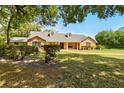 Traditional single-story home on a sprawling lawn surrounded by lush trees at 3075 Simpson Rd, Kissimmee, FL 34744