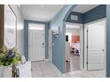 Bright foyer featuring tile floors, a white front door, and a view of a stylishly decorated bedroom at 3161 Royal Tern Dr, Winter Haven, FL 33881