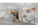 Open dining area featuring a modern table and chair set with a view into the kitchen at 3344 Corona Village Way # 308, Orlando, FL 32835