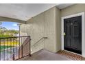 Condo entryway featuring a black front door and a view of the nearby lake at 3344 Corona Village Way # 308, Orlando, FL 32835