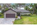 Charming single-story home with a brick driveway, two-car garage, and well-manicured lawn and landscaping at 420 Ketch Rd, St Cloud, FL 34771