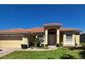 Beautiful single-story home featuring a barrel tile roof and a well-manicured lawn at 448 Cinnamon Dr, Kissimmee, FL 34759