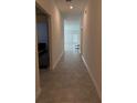 Bright hallway featuring neutral tile flooring leading to a naturally lit living space at 4812 Worchester Dr, Kissimmee, FL 34746