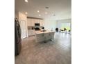 Open-concept kitchen with white cabinets, stainless appliances, island with seating and breakfast nook at 4812 Worchester Dr, Kissimmee, FL 34746