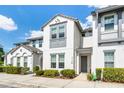 Charming townhome with white stucco, gray trim accents, and lovely landscaping, creating curb appeal at 510 Captiva Dr, Davenport, FL 33896
