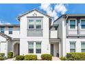 Two-story townhome exterior featuring white stucco, a gray accent trim, and well-maintained landscaping at 510 Captiva Dr, Davenport, FL 33896