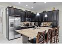 Stylish kitchen featuring dark cabinetry, granite countertops, stainless steel appliances, and a large island at 510 Captiva Dr, Davenport, FL 33896