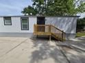 Exterior side view of the house with new wooden steps to the front door at 5161 Howison Rd, Kissimmee, FL 34746