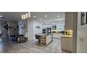 Well-lit kitchen with modern finishes, island seating, stainless appliances, and views to the living room at 5340 Jubiloso Dr, St Cloud, FL 34771
