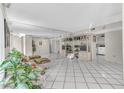 Spacious living room with tile flooring, a large mirrored wall, and bright, neutral tones at 5912 Village Cir # Ge, Orlando, FL 32822
