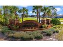 Brick Nova Bay community sign surrounded by manicured landscaping and palm trees at 6186 Oak Shore Dr, St Cloud, FL 34771
